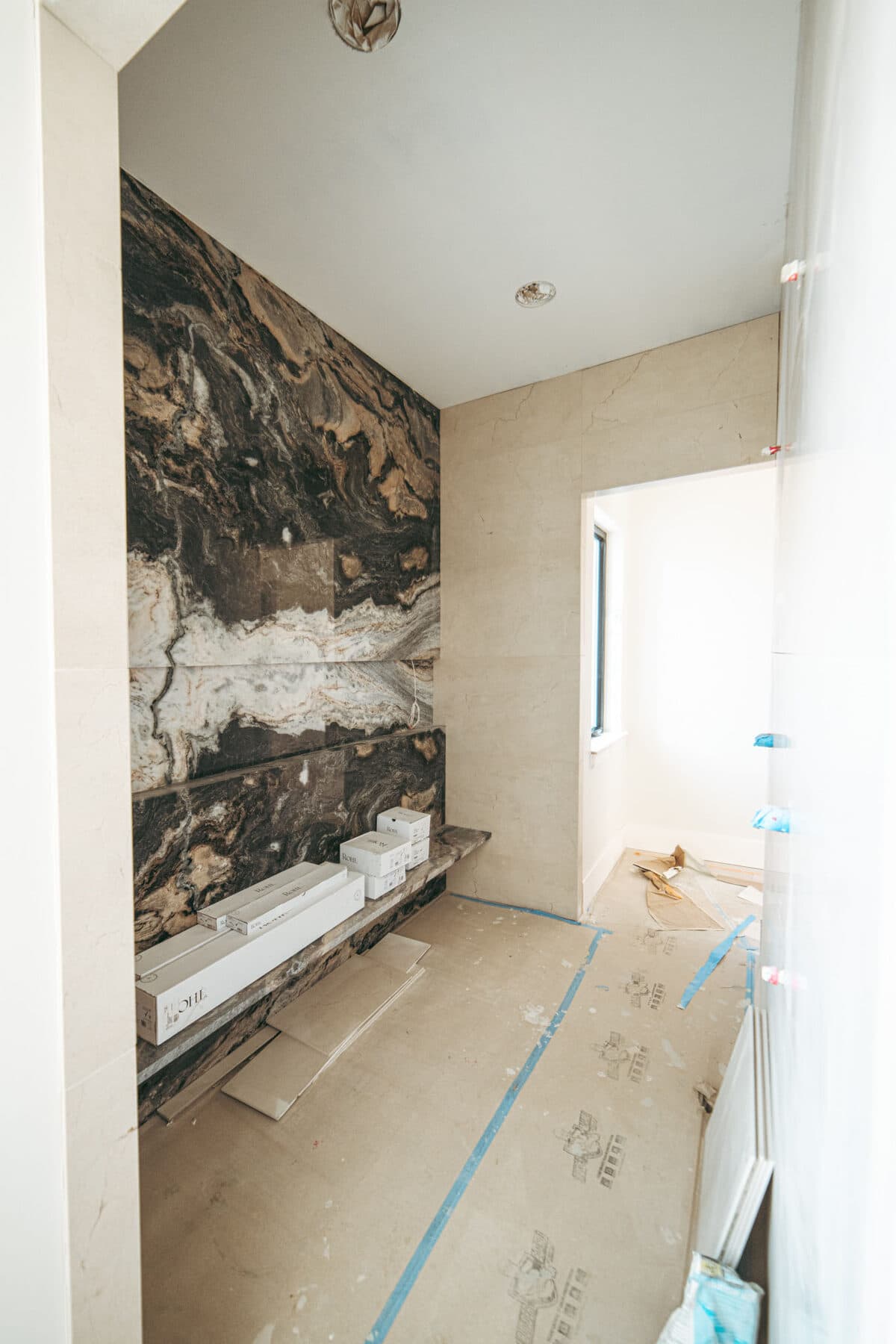 Alla Famiglia — primary bath with hand-troweled plaster walls and checkered marble flooring